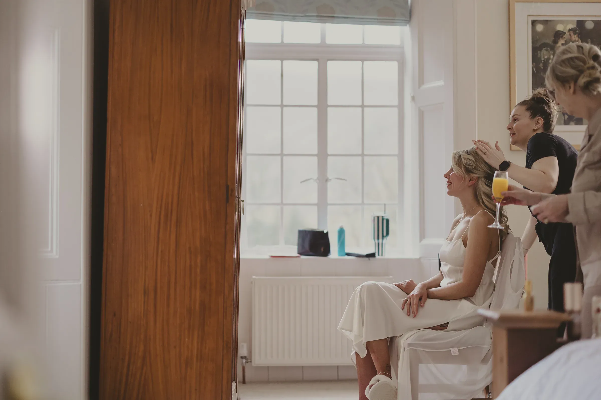 Katie has her hair styled while getting ready inside one of the Glenclova lodges on her wedding day.
