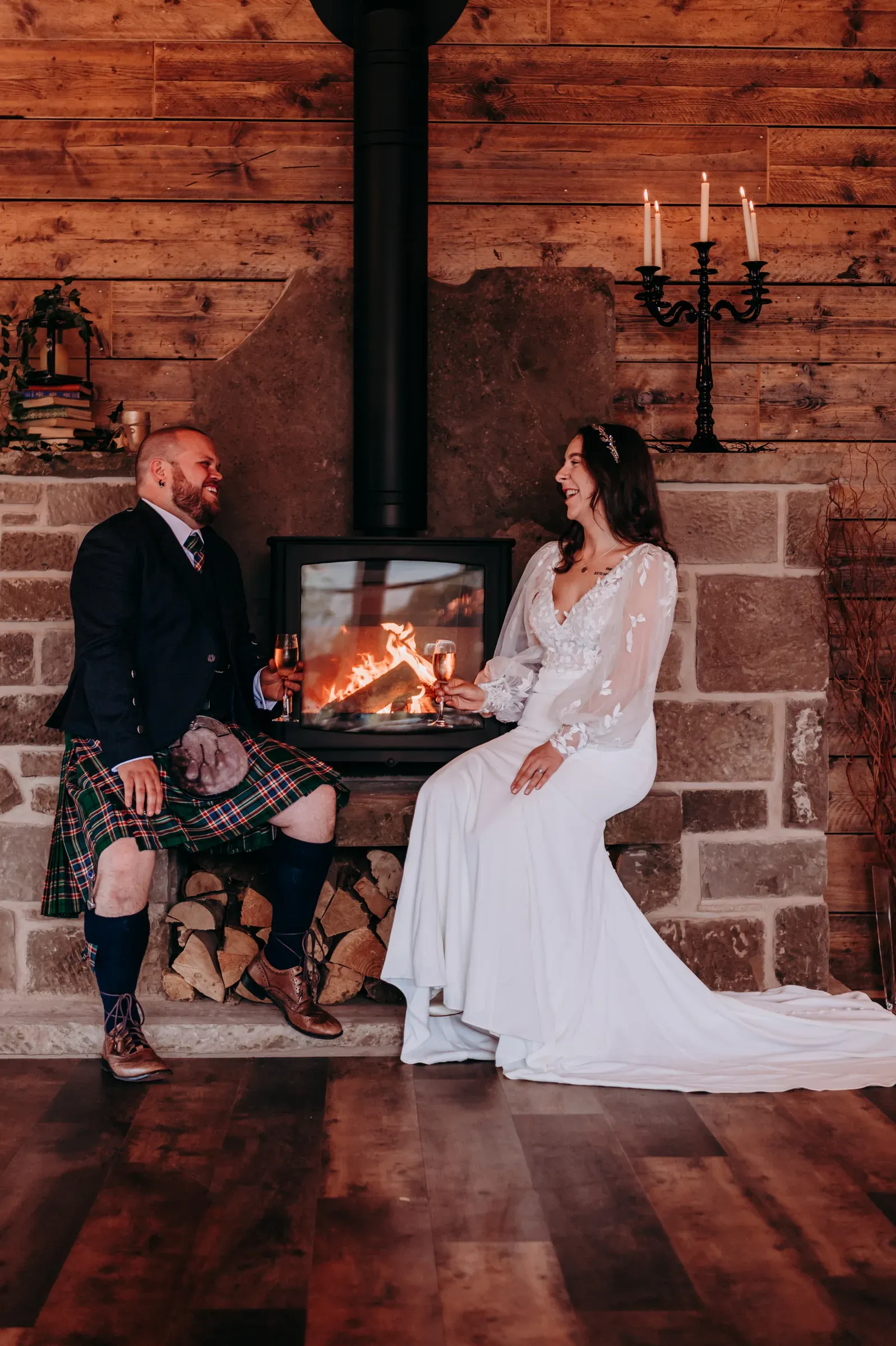 Sam and Cam share a loving, laughter-filled moment with drinks while sitting by the fireplace in the barn.