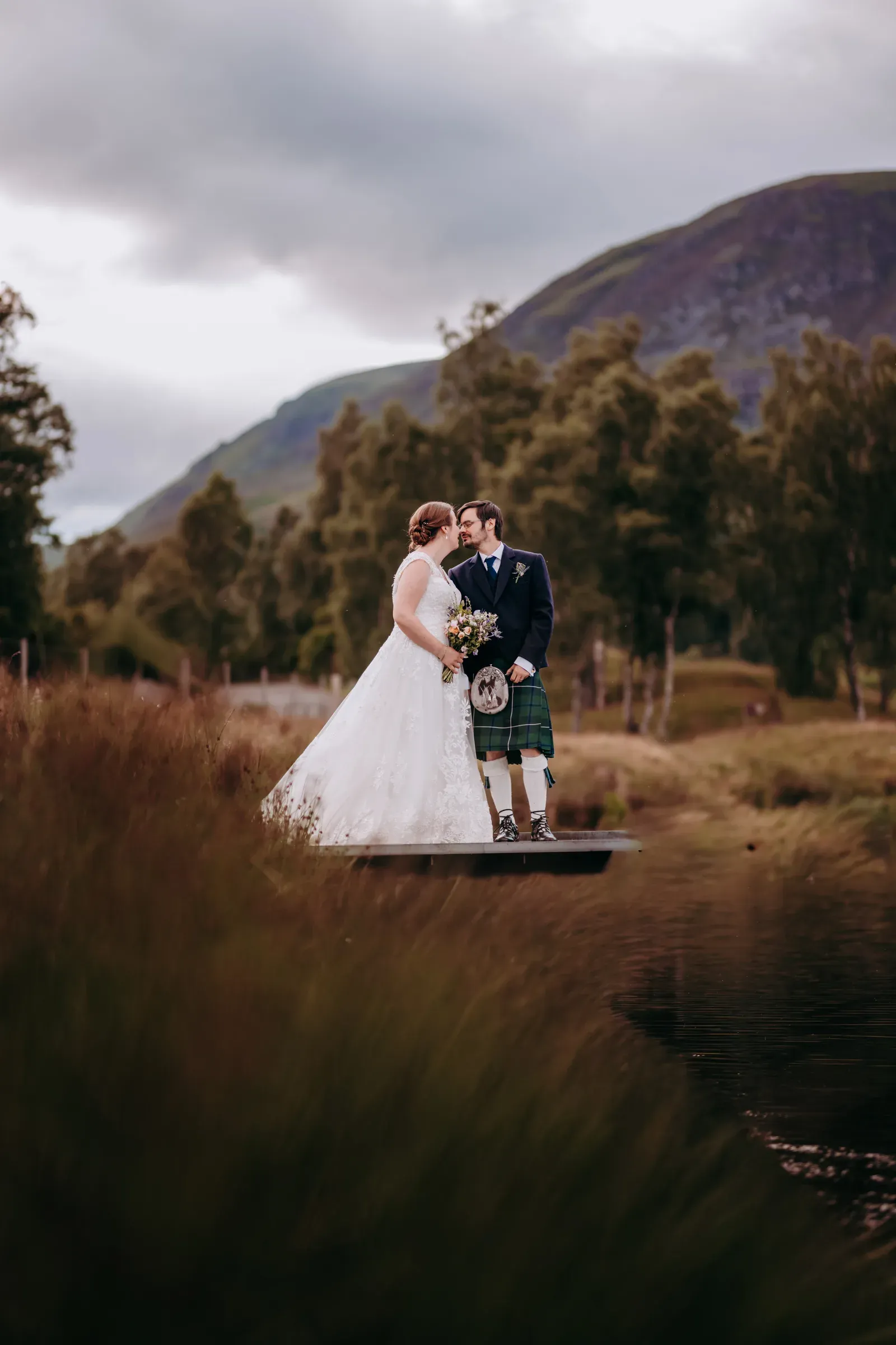 Heather and Louis share a romantic moment by the water at one of the scenic photo spots in Glen Clova.