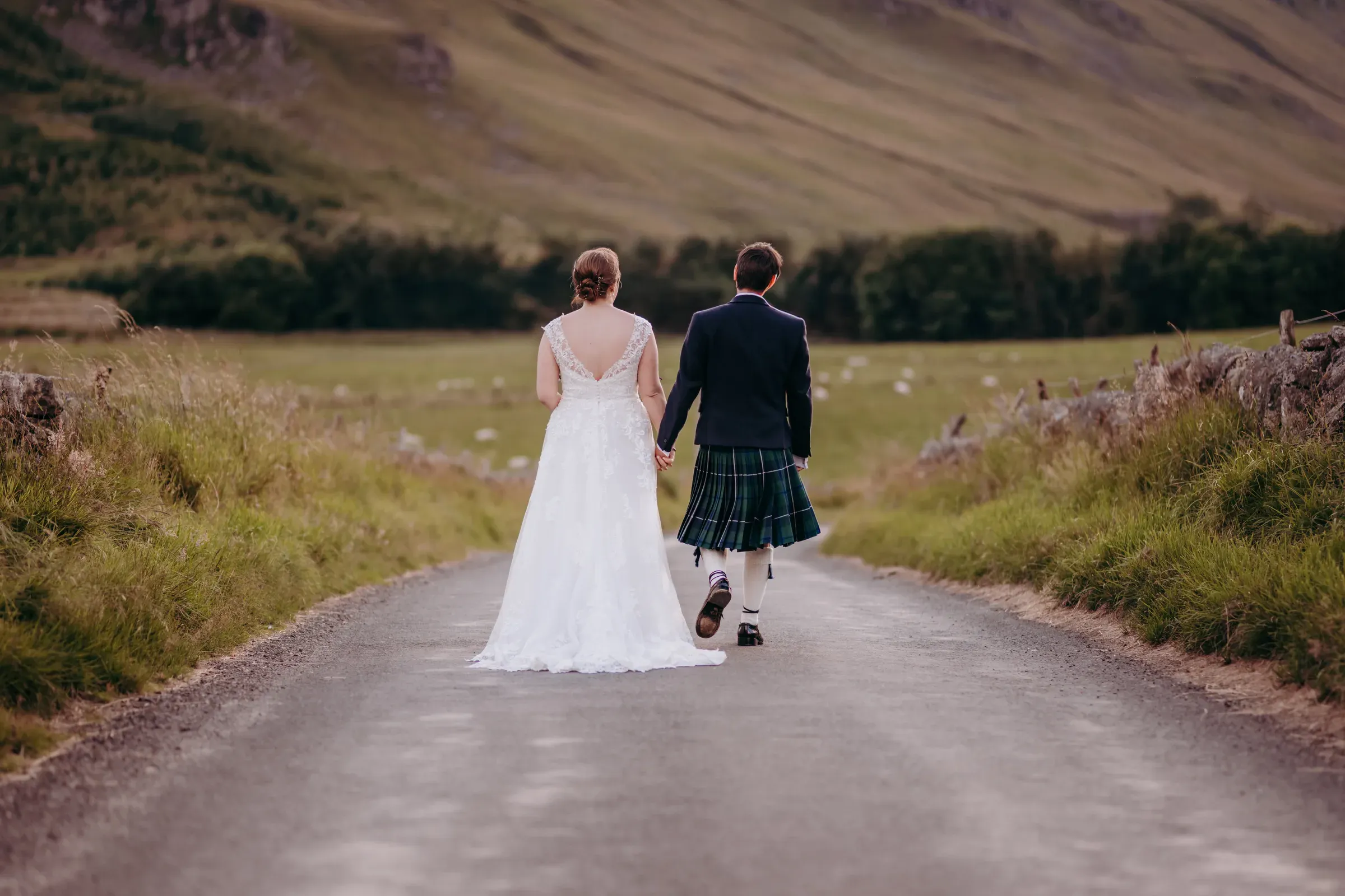 Newlyweds Heather and Louis hold hands and walk together into the Glen.