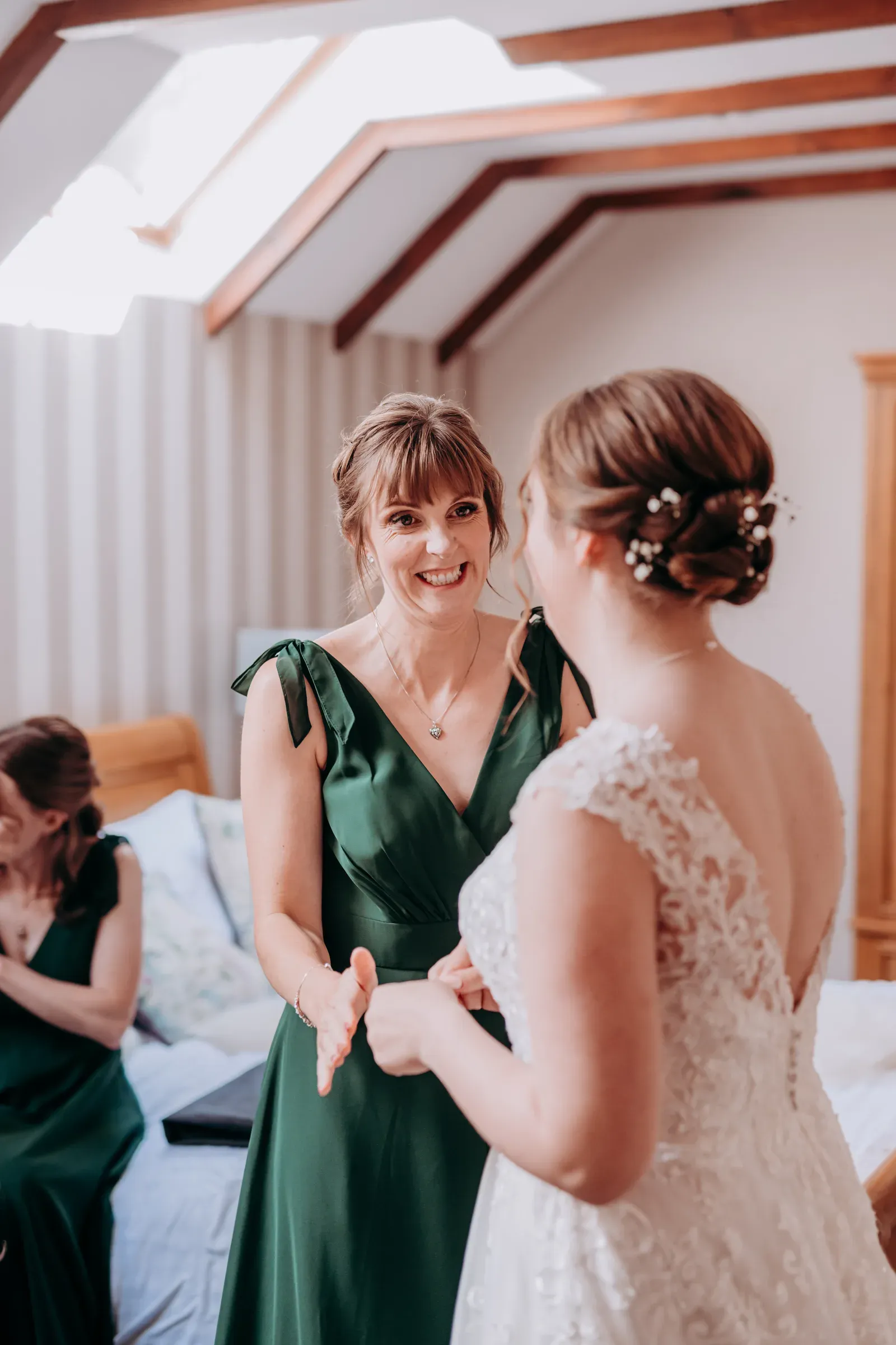A bride and her bridesmaid share a joyful moment while getting ready inside one of the Glenclova lodges before the wedding ceremony.