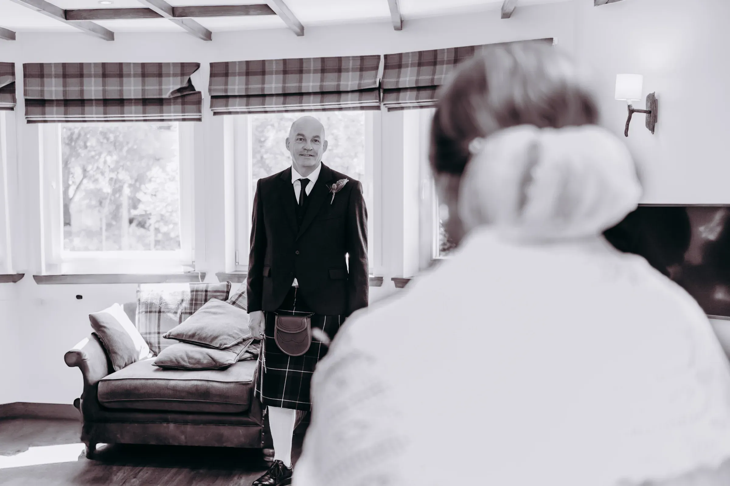 The father of the bride looks towards his daughter in a magical moment inside the Old Mill Lodge.