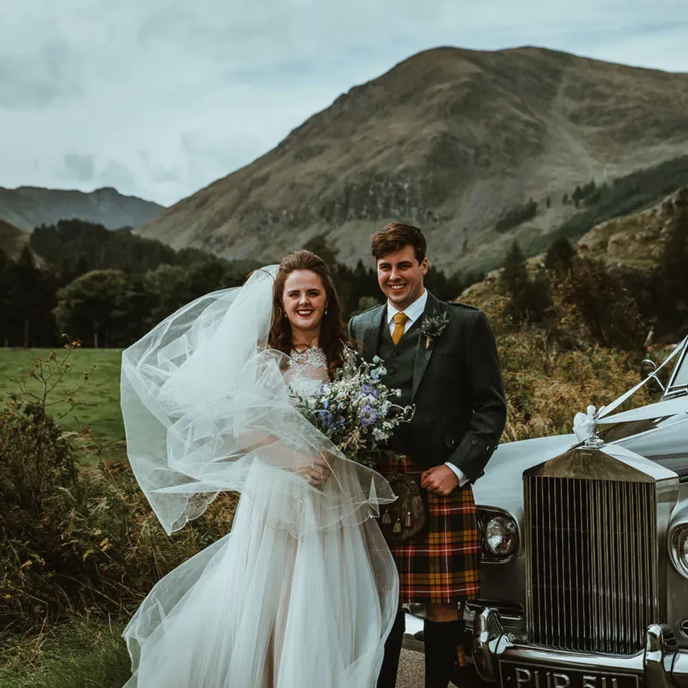 A happy wedding couple poses together in the Scottish Highlands.