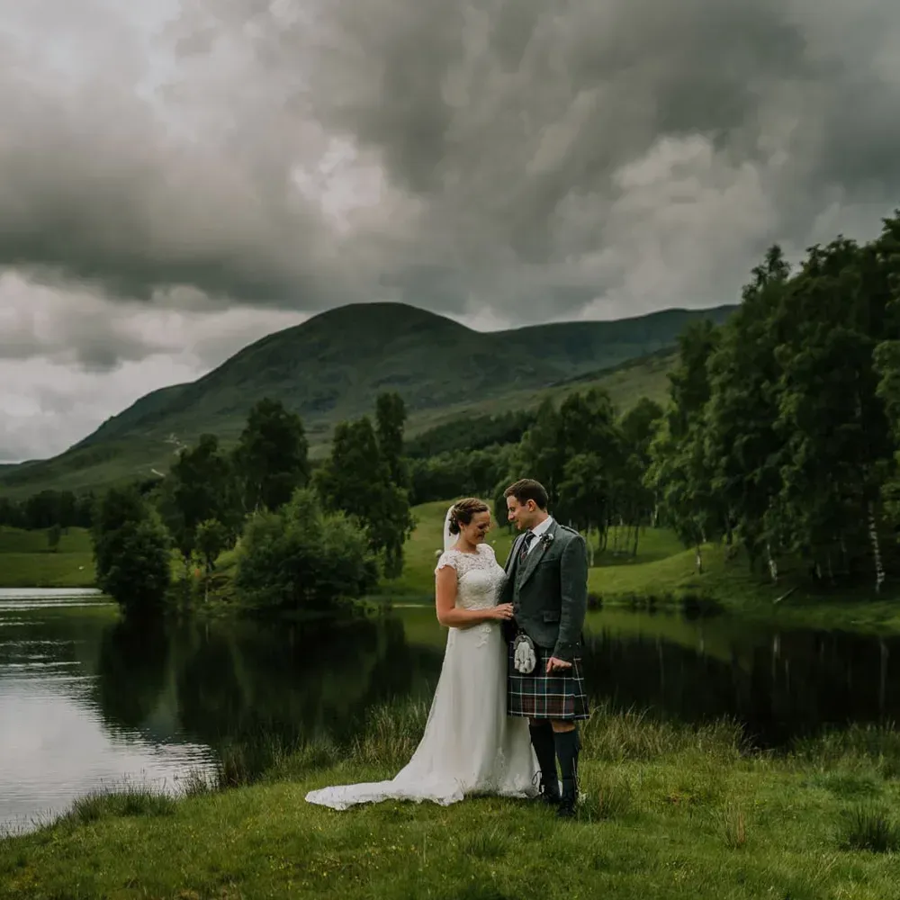A happy wedding couple stands together in the Scottish Highlands at Glenclova.