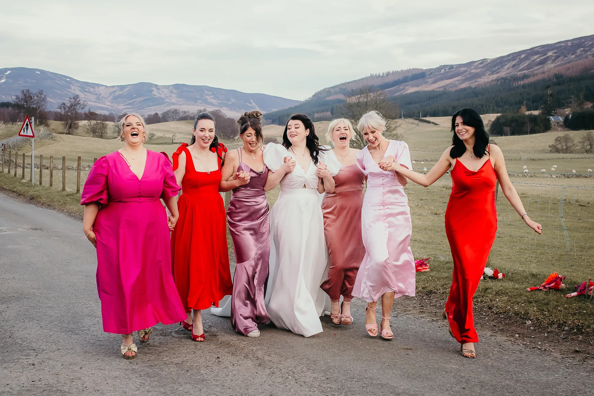 Meg and her bridesmaids enjoy a walk together along the glen road with the Scottish Highlands in the background.