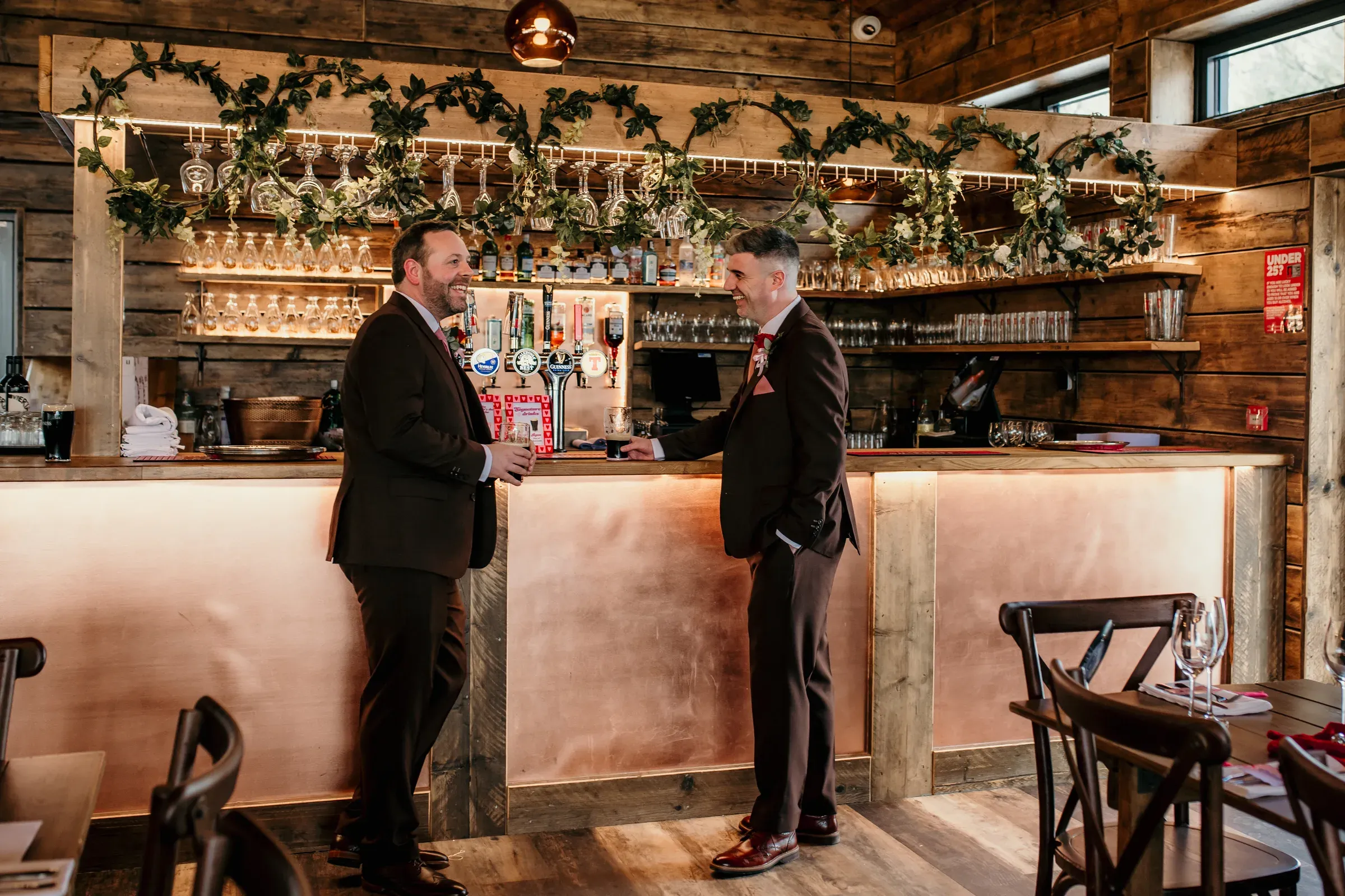 Ryan and his best man share a drink and a laugh at the bar inside the Glenclova barn.