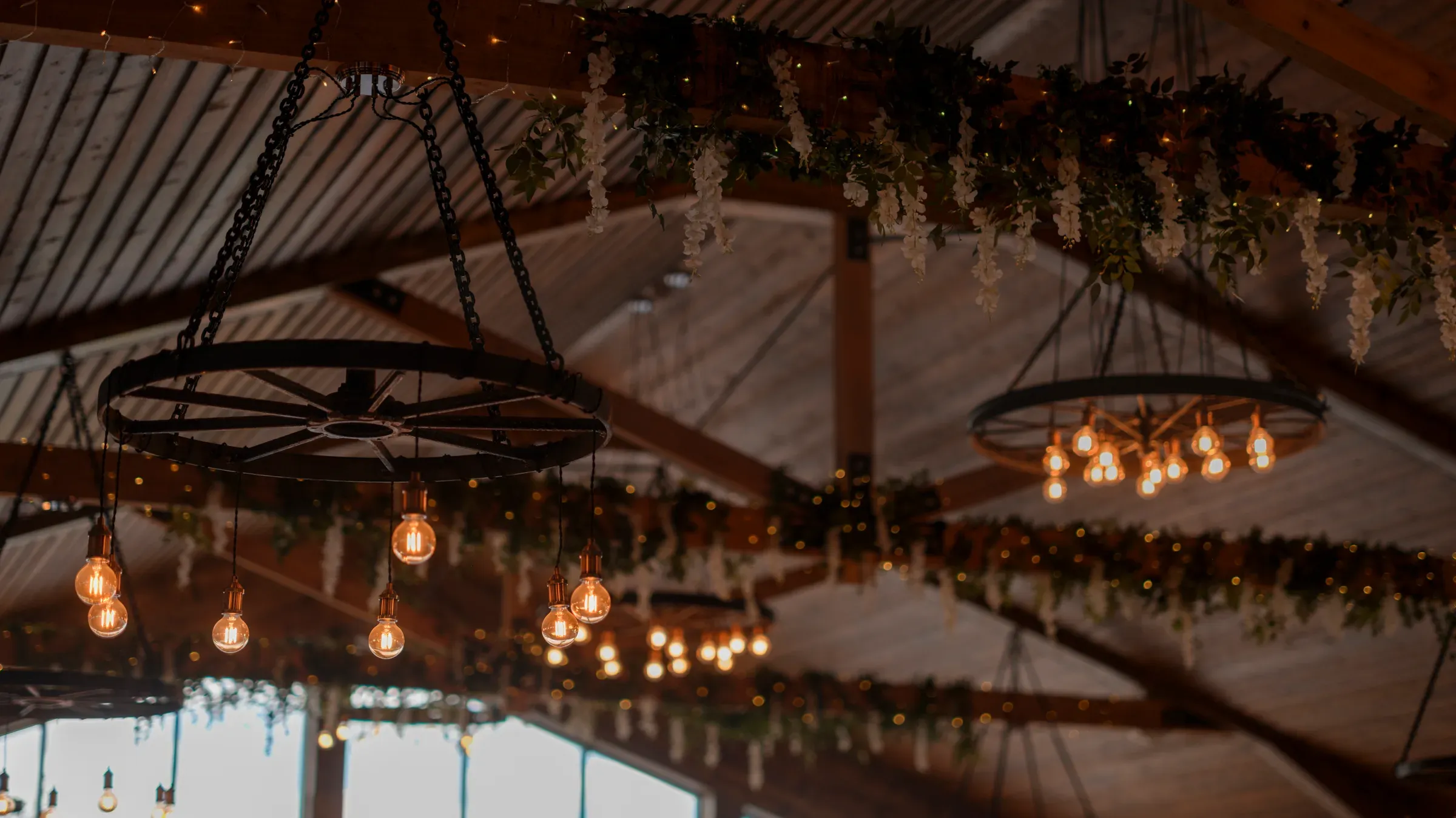 A cosy view of the barn interior featuring hanging lights and floral fauna decorations.