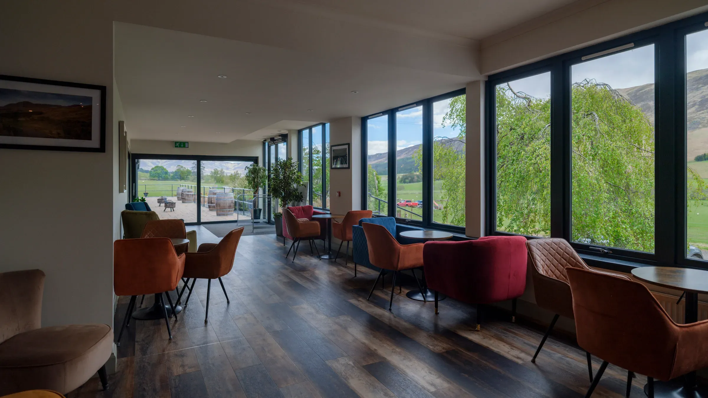 A view of the hotel reception and entrance area featuring comfortable seating and large windows overlooking the glen.