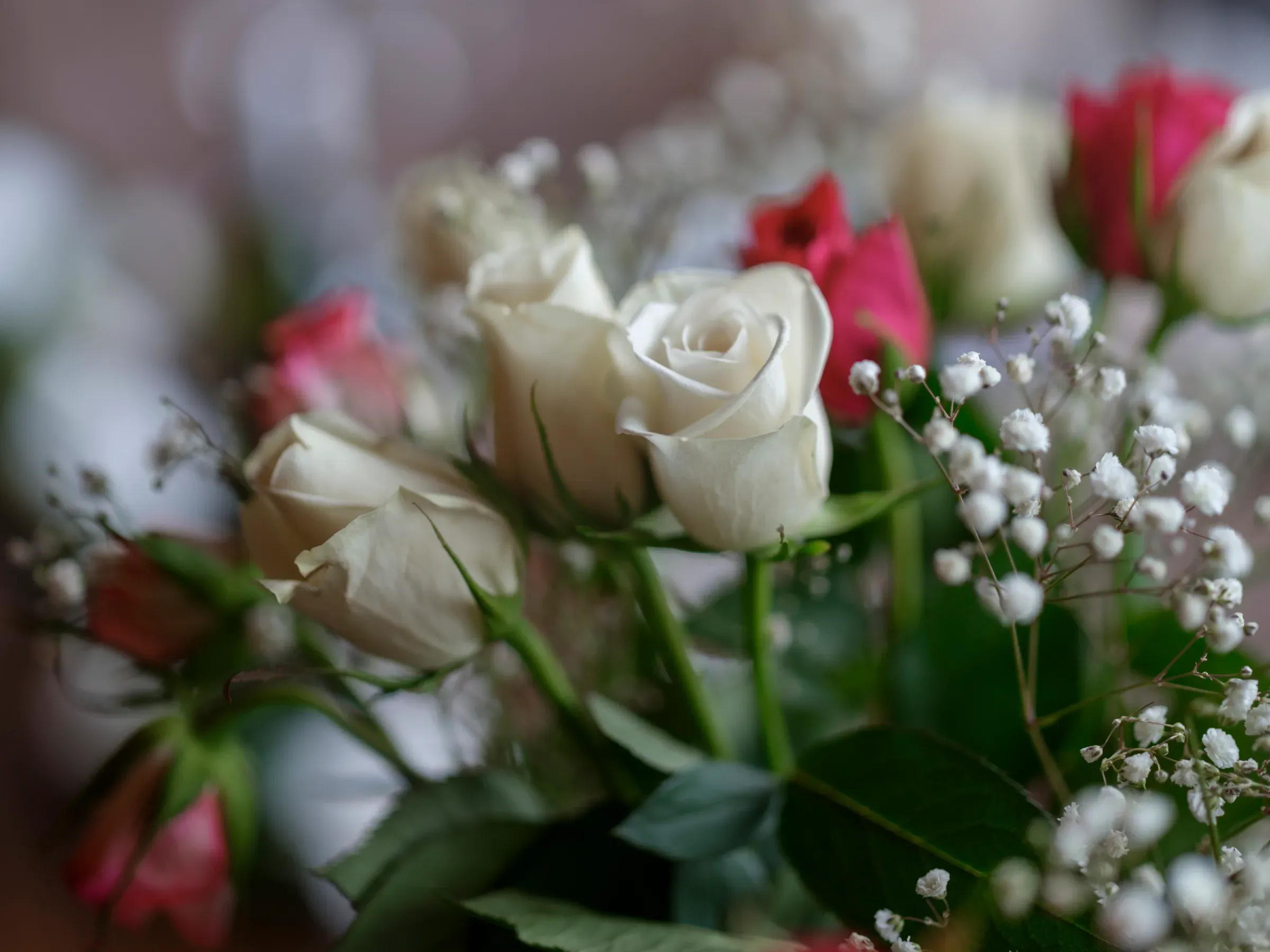 A beautiful up-close shot of wedding flowers featuring white and pink roses that signify love.