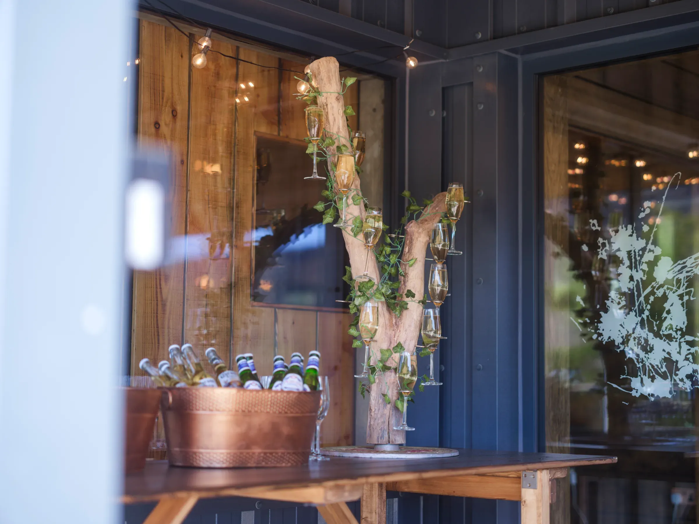 A decorative champagne tree displayed on a table outside the barn venue.