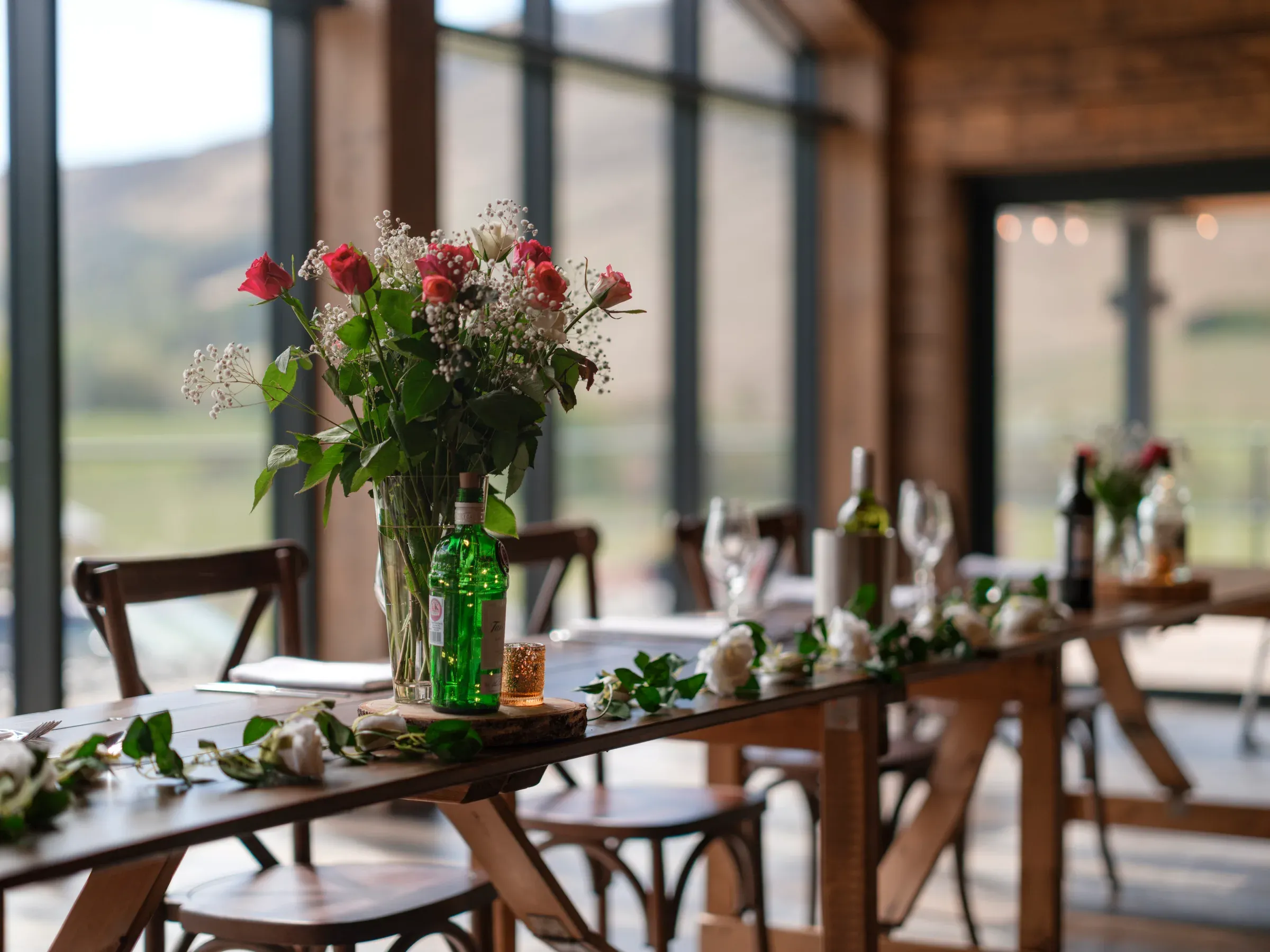 A beautiful floral arrangement displayed on a dining table inside the barn venue.