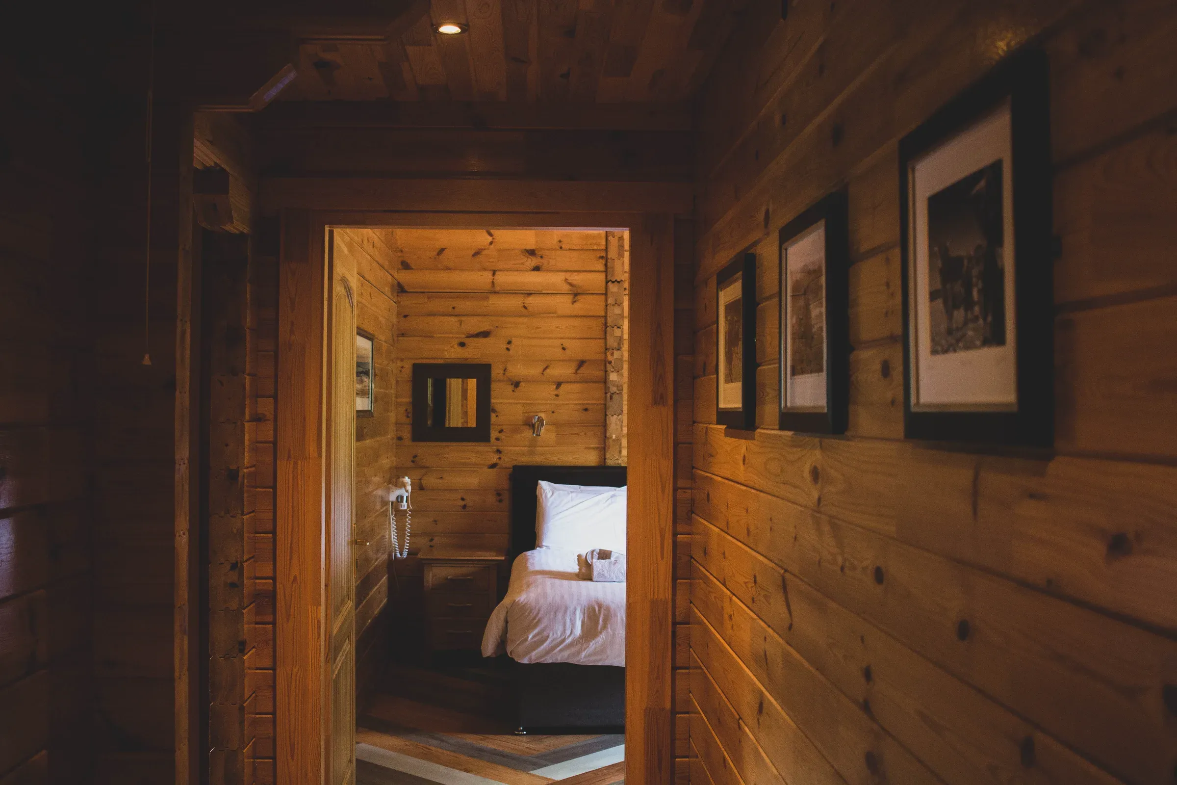 A view looking through a doorway into a cozy bedroom inside the lodge.