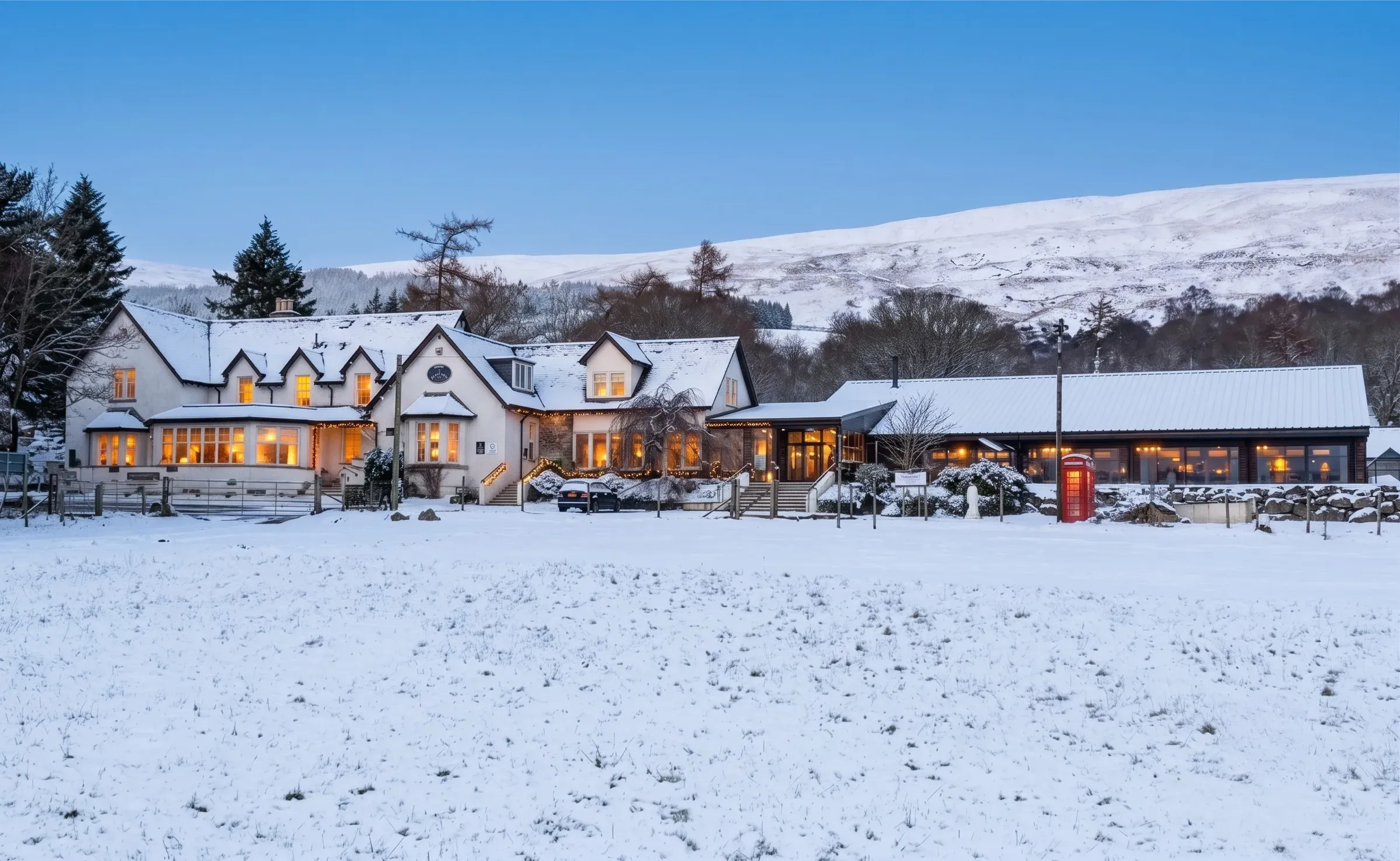 A winter view of the Glenclova hotel illuminated against a snow-covered landscape.