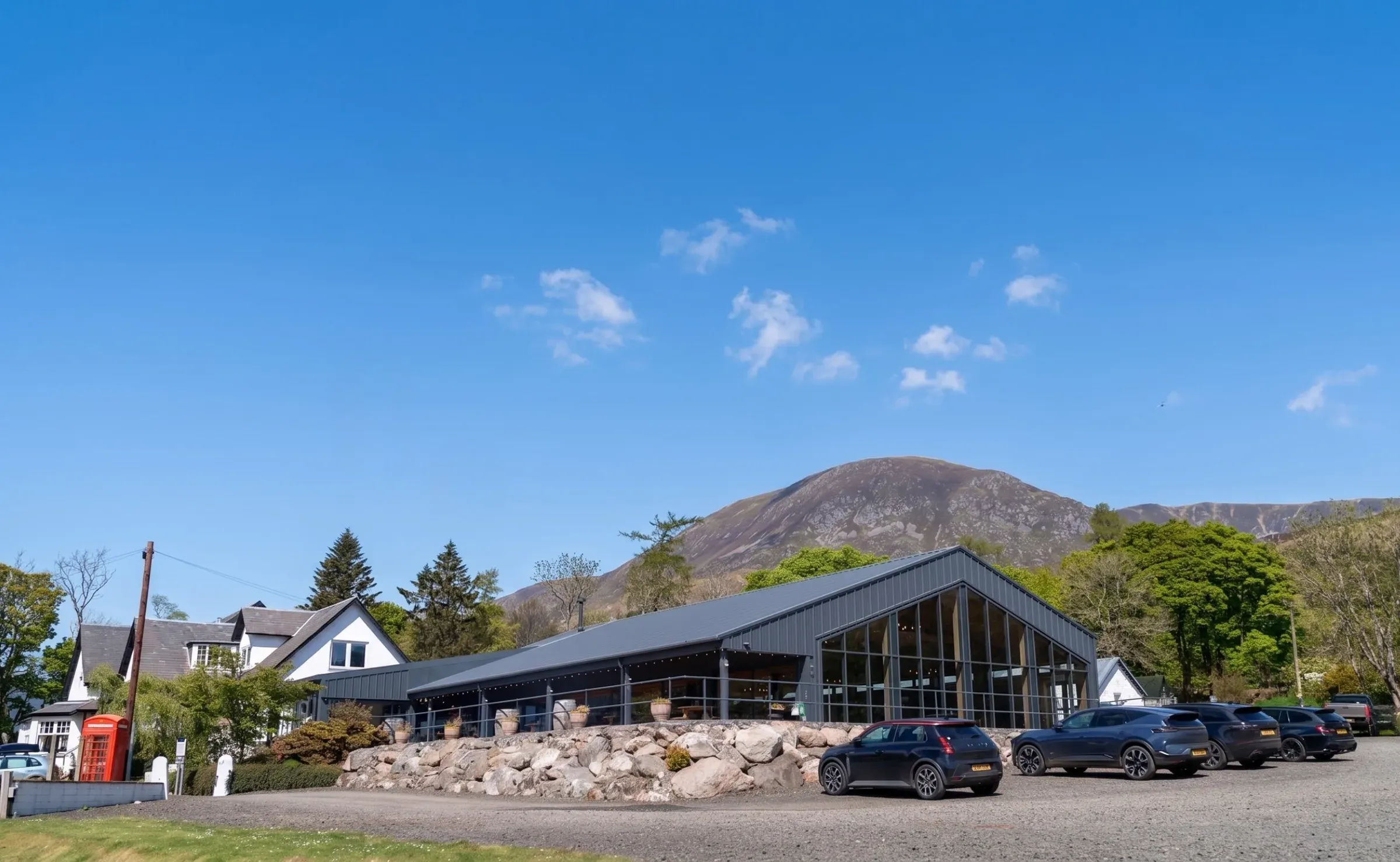 A view of the Glenclova venue buildings set against a mountain backdrop on a clear summer day.