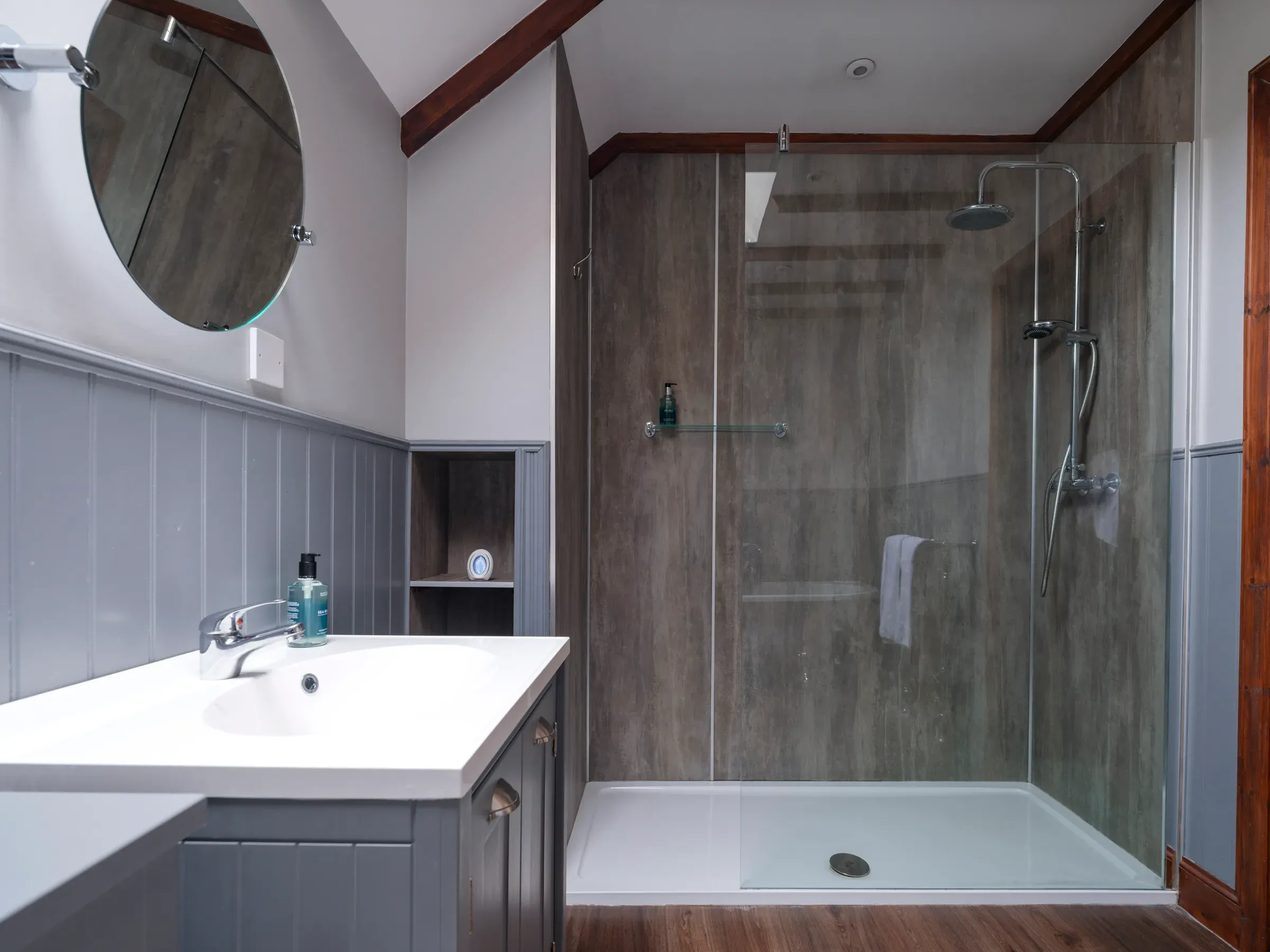 A modern bathroom inside the Glenclova lodge featuring a walk-in shower and vanity unit.