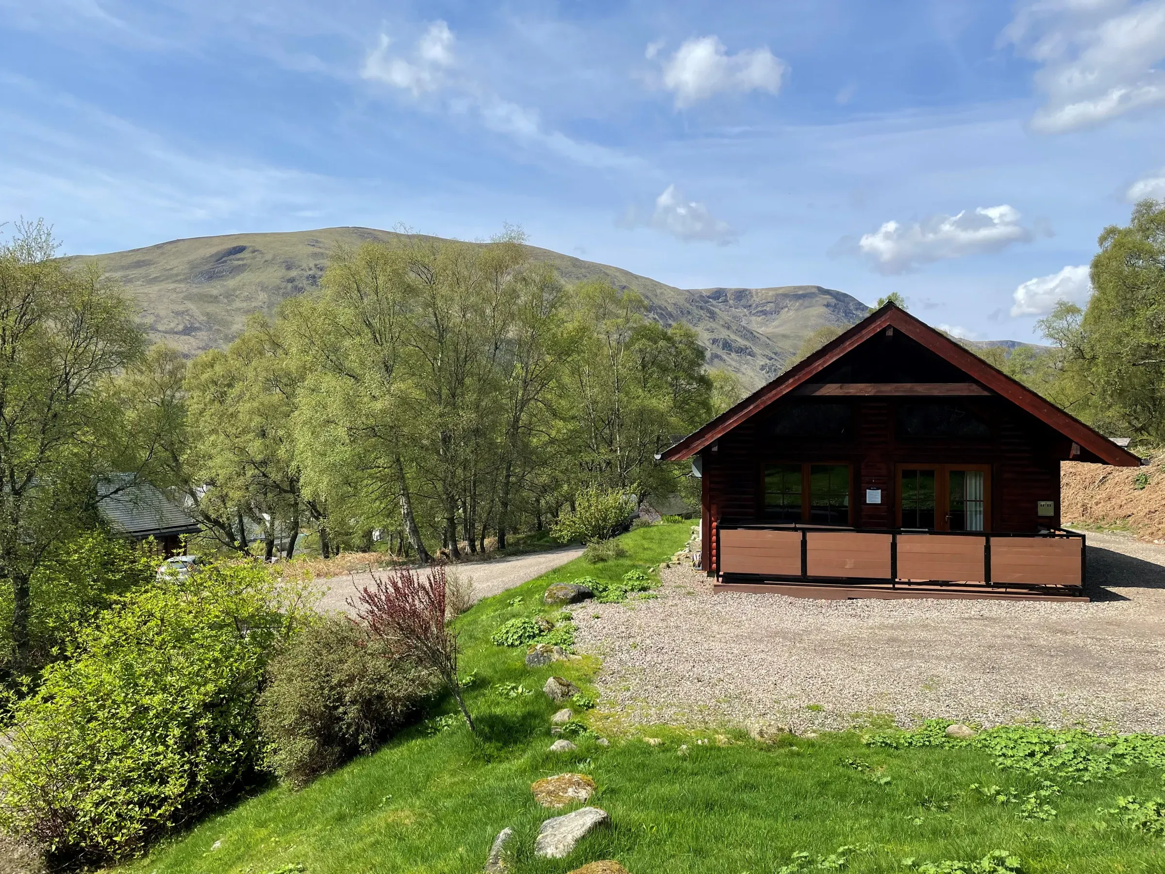 An exterior view of a lodge set within the scenic Scottish Highland landscape.