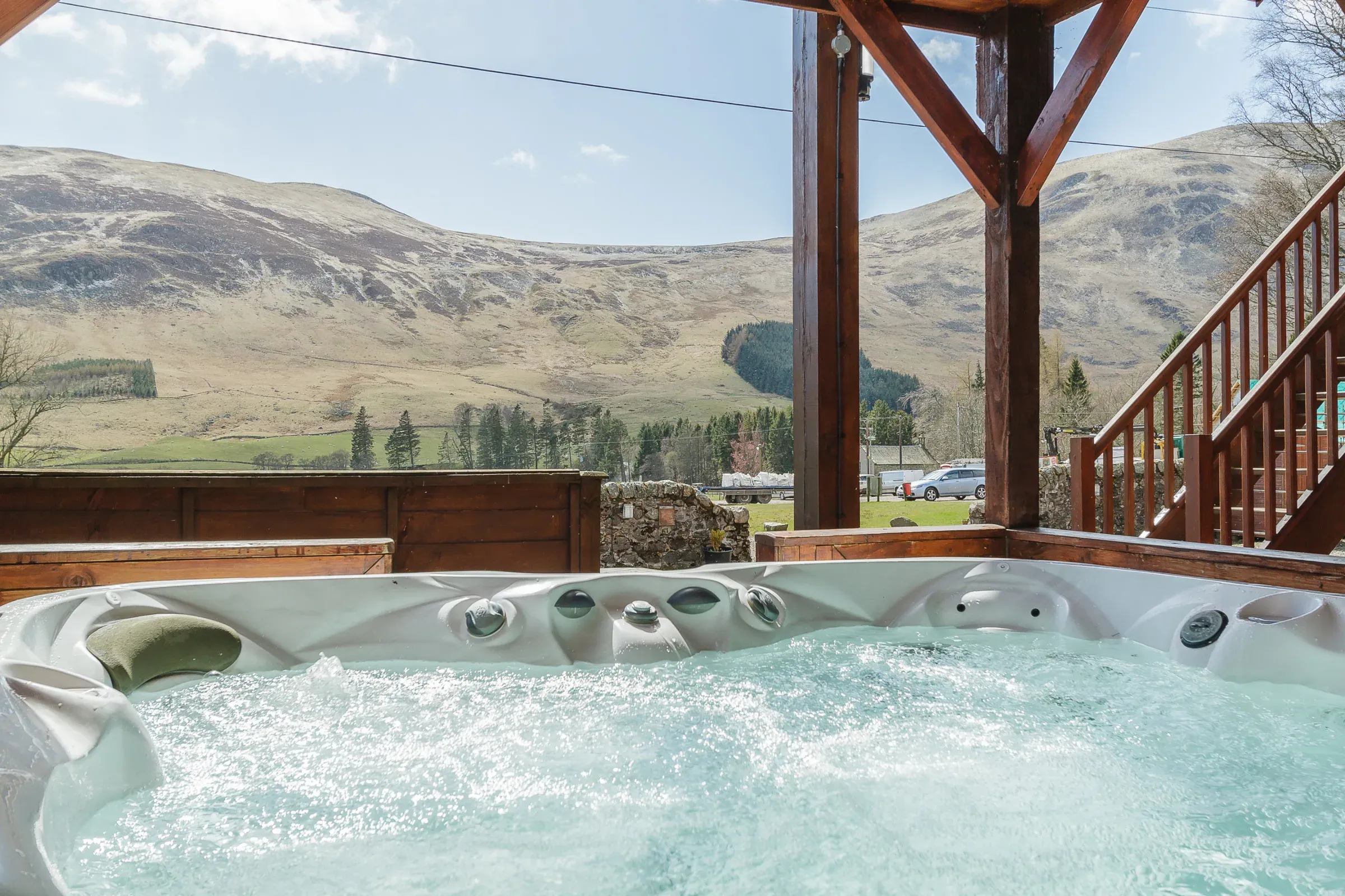 A view from a bubbling hot tub looking out towards the scenic Highland glen landscape from one of the venue's lodges.
