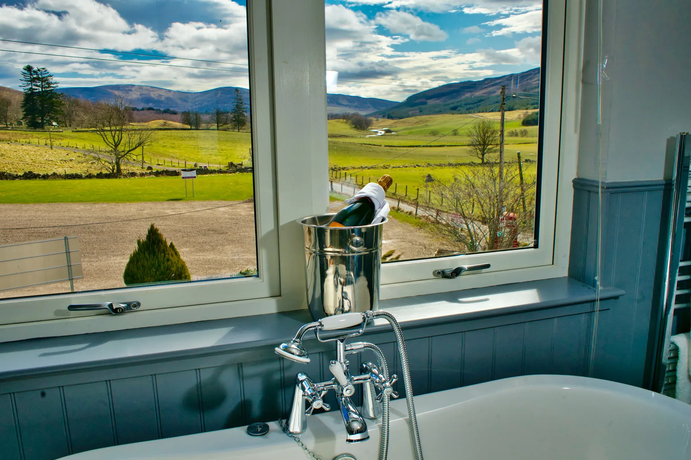 A view from the junior suite looking out over the glen with a bottle of champagne chilling by the bathtub.