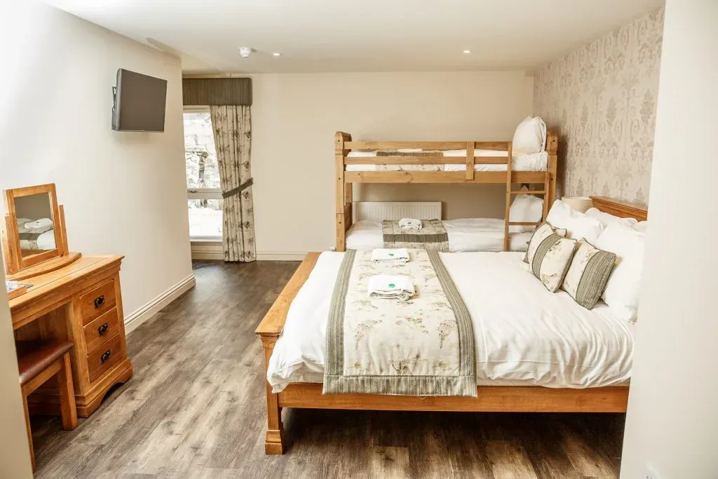 A view of the family room in the steading featuring a double bed and bunk beds.
